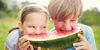 Foto: Zwei Kinder beißen in ein Melonenstück