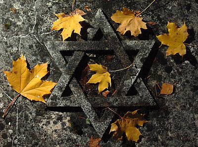 Herbstlaub liegt auf einer Grabplatte auf einem jüdischen Friedhof