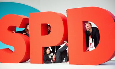 Foto: Mitglieder der Jugendorganisation der SPD (Jusos) posieren beim Bundesparteitag 2015 am SPD-Logo in Berlin.