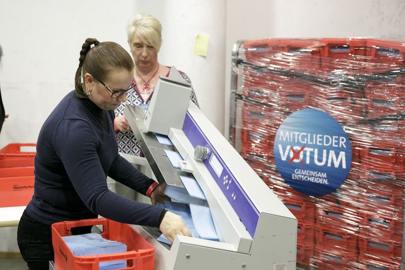 Foto: Freiwillige öffnen die Wahlbriefe mithilfe einer Hochleistungsschlitzmaschine