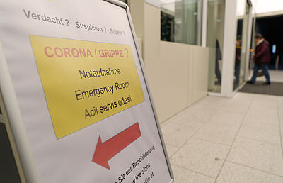 Foto: Ein Schild "Verdacht - Corona / Grippe - Notaufnahme" ist vor einem Krankenhaus aufgestellt.