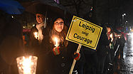 Foto: Eine Frau hält am 11.01.2016 in Leipzig ein Schild mit der Aufschrift "Leipzig zeigt Courage" in der Hand und demonstriert damit gegen das islamkritische Legida-Bündnis.