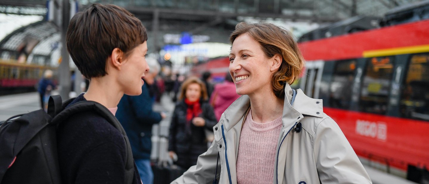 Foto: Freundinnen begrüßen sich auf Bahnsteig im Hauptbahnhof Berlin