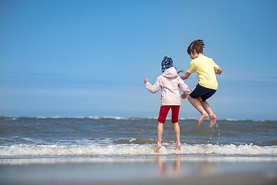 Foto: Zwei Kinder spielen am Strand.