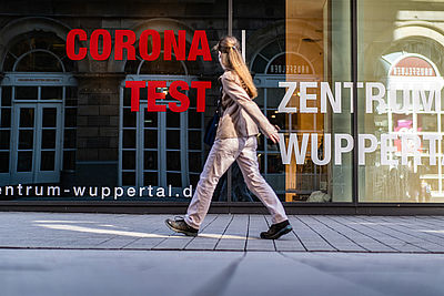 Foto: Eine Frau geht am Corona-Test-Zentrum in der Wuppertaler Innenstadt vorbei.