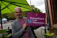 Imo/Photothek Foto: Mann hält Willkommen heißen Schild