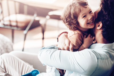Symbolfoto Thema Familie: Vater umarmt sein Kind