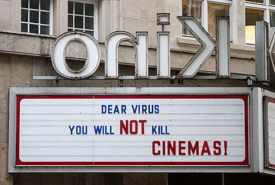 Foto: Der Schriftzug "Dear virus - You will not kill cinemas!" ist an der Leuchtreklame eines Kinos angebracht.