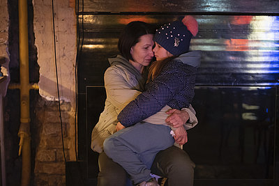 Foto: Eine Frau hält ihre Tochter im Arm, während sie in einem als Luftschutzbunker genutzten Keller in Kiew sitzt