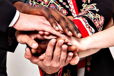 Foto: Menschen verschiedener Nationen schlagen die Hände übereinander