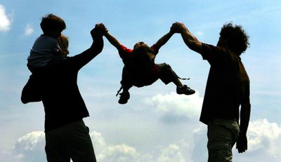 Eltern wirbeln ihr Kind durch die Luft. (Foto: dpa)