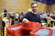 Thomas Imo / photothek.net Foto: Ein Freiwilliger nimmt ein Kasten mit Stimmunterlagen zur Auszählung