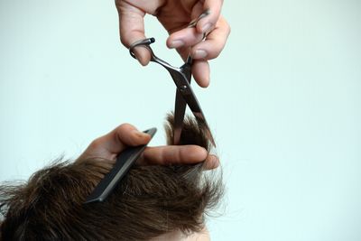 Foto: Ein Friseur schneidet einem Mann die Haare.