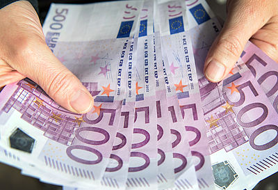 Foto: Eine Frau zählt 500-Euro-Geldscheine.