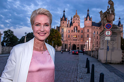 Foto: Manuela Schwesig steht vor dem Schweriner Schloss, dem Sitz des Landtags.