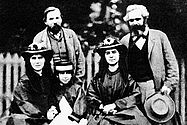 https://www.marxists.org/archive/marx/photo/family/pages/64daug.htm Foto: Karl Marx (r.) mit seinen drei Töchtern Laura, Eleanor und Jenny (vorne v.l.) und seinem Freund Friedrich Engels 1864.