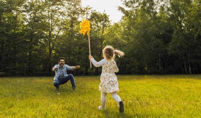 Foto: Vater und Tochter spielen auf einer Wiese